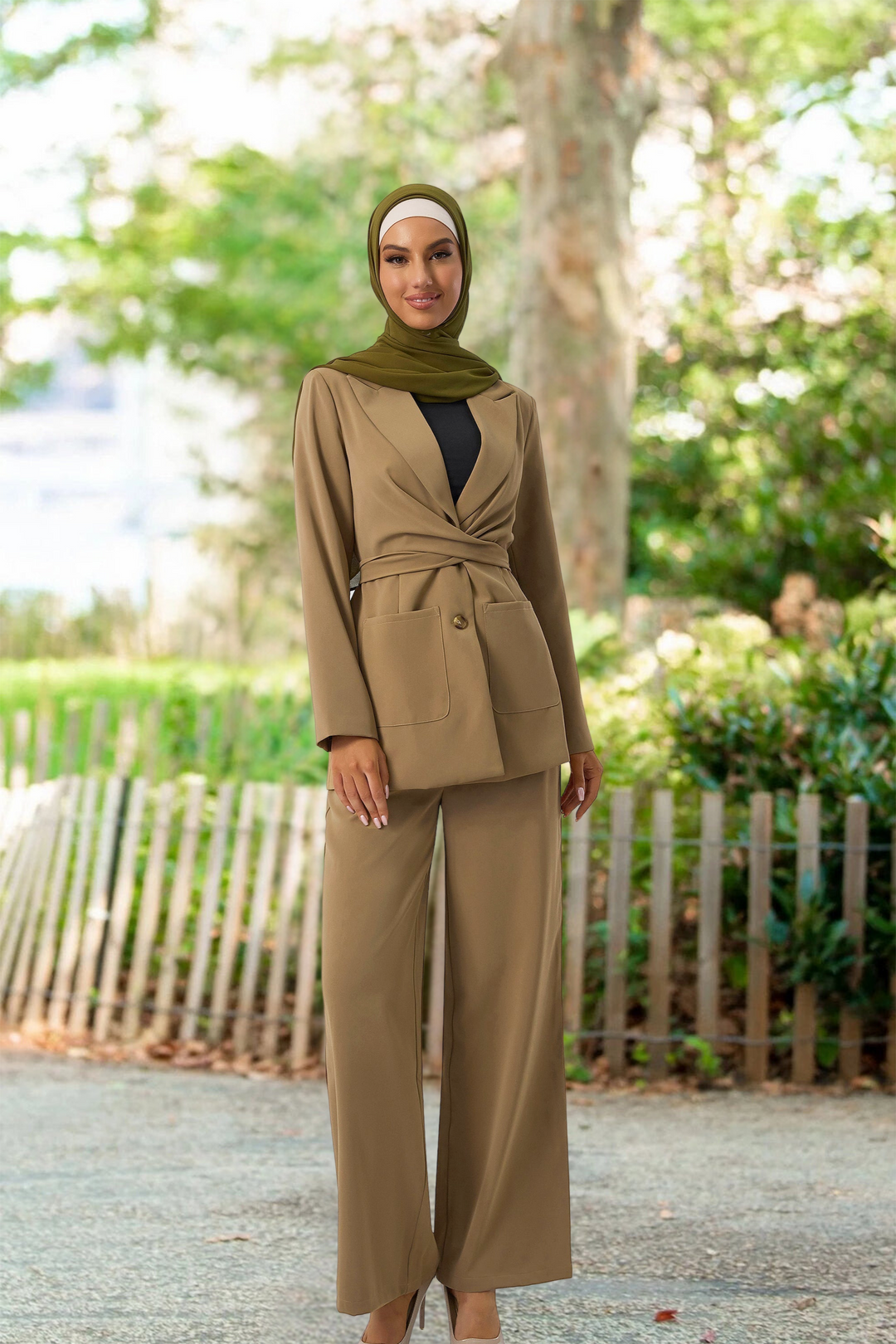 Woman in a tan pantsuit and green hijab modeling a stylish taupe jacket and pants suit