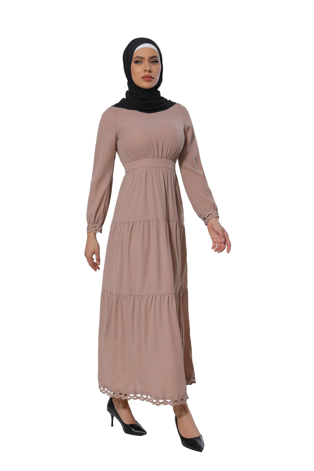 Woman in a long-sleeved taupe lace tiered maxi dress with a black hijab