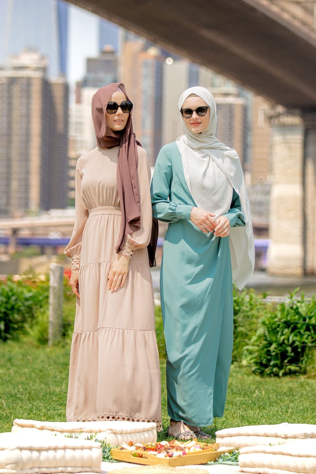 Two women in hijabs wearing taupe lace tiered maxi dresses showcasing fashionable modesty