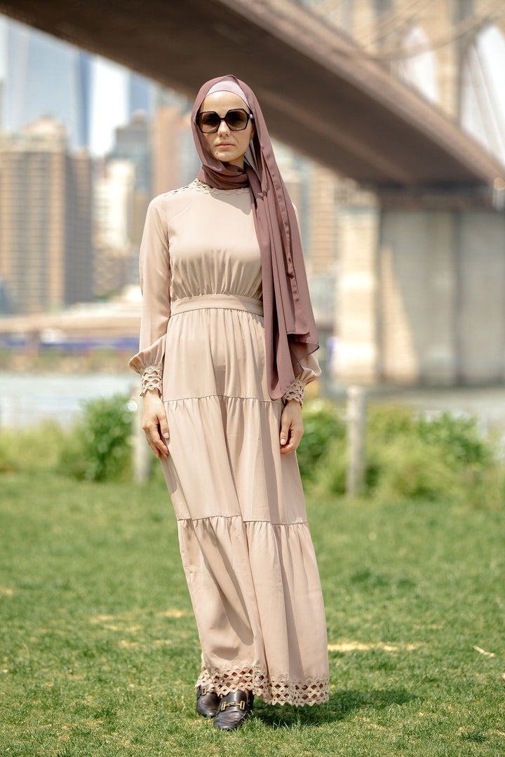 Woman in a taupe lace tiered maxi dress with hijab showcasing elegance and style