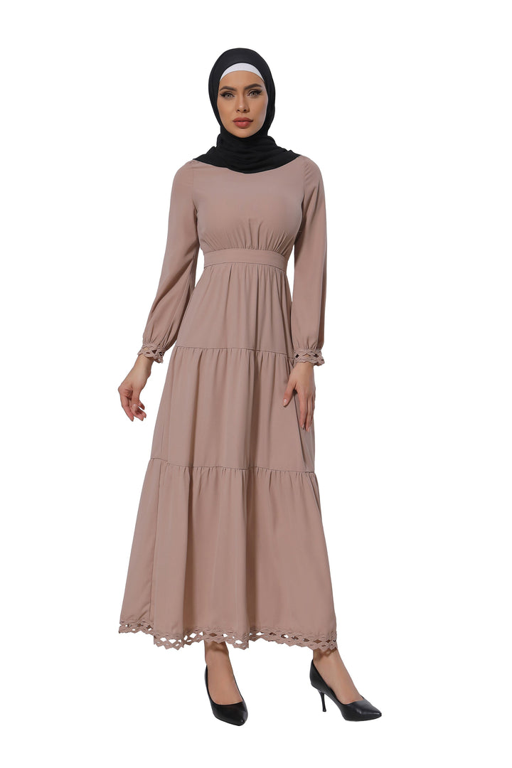 Woman in a taupe lace tiered maxi dress with hijab showcasing clearance style