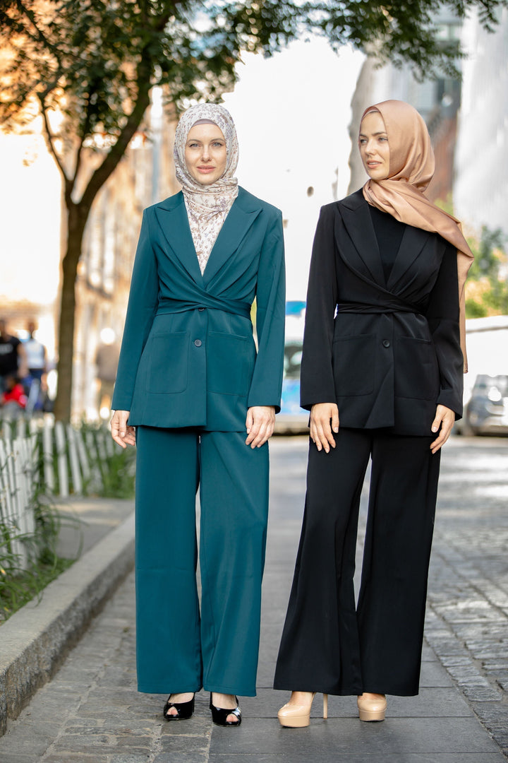 Two women modeling a teal jacket and pants suit from the CLEARANCE collection