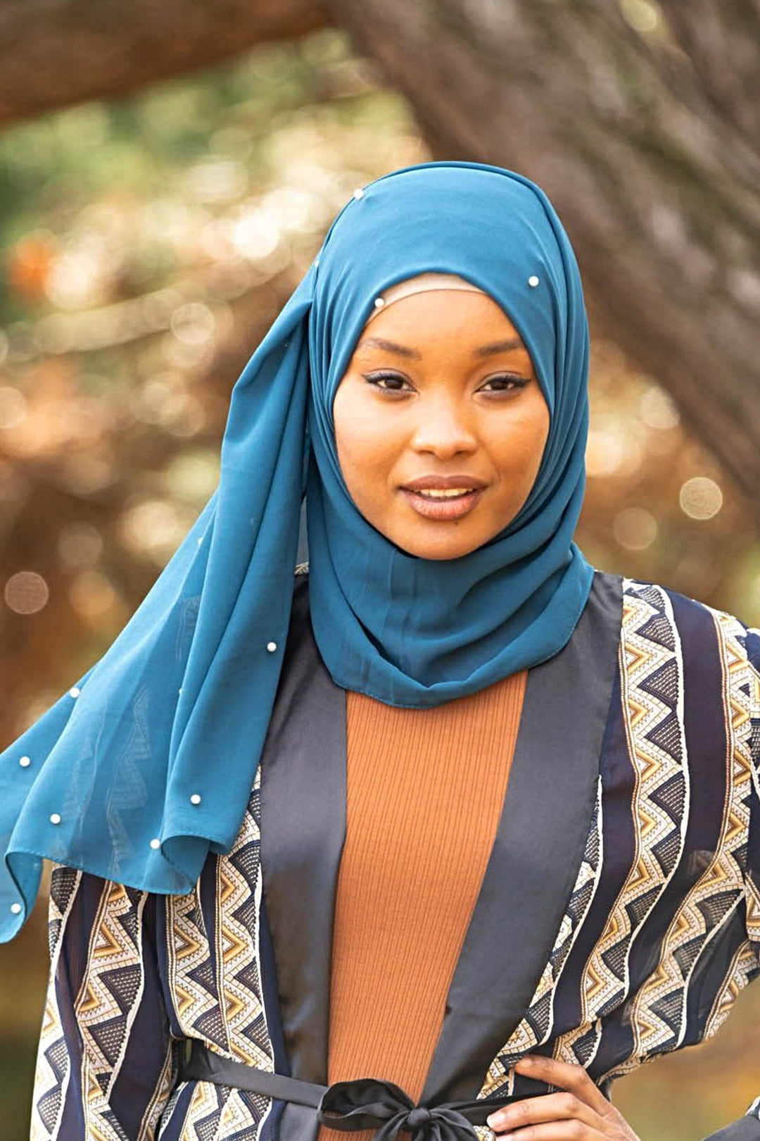 Woman wearing a teal Pearl Chiffon hijab highlighting elegance and style