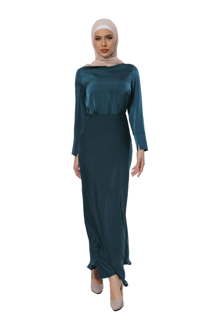 Woman in a teal satin long sleeve skirt set and hijab, showcasing elegant style