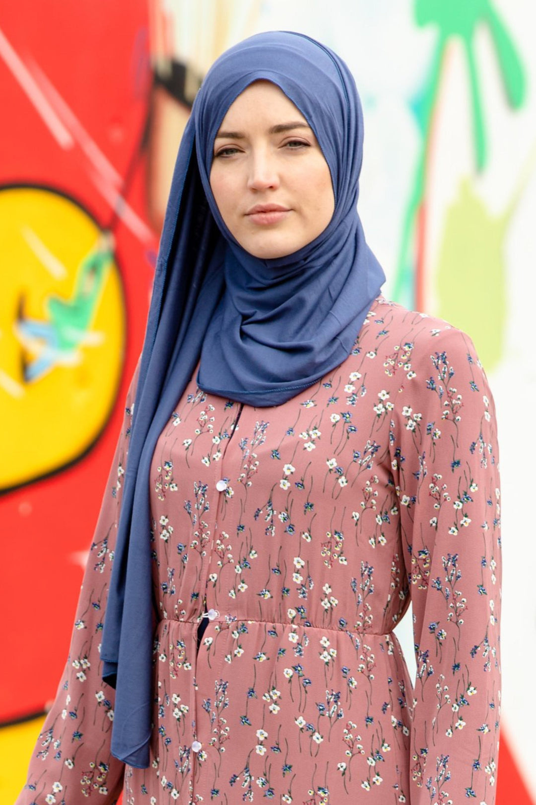 Woman in hijab and floral dress showcasing Topaz Blue Jersey Hijab