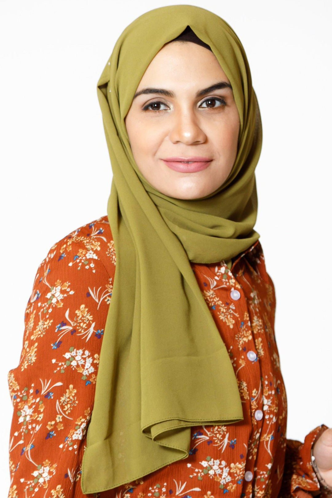 Woman in a green chiffon hijab and floral shirt showcasing urban modesty style