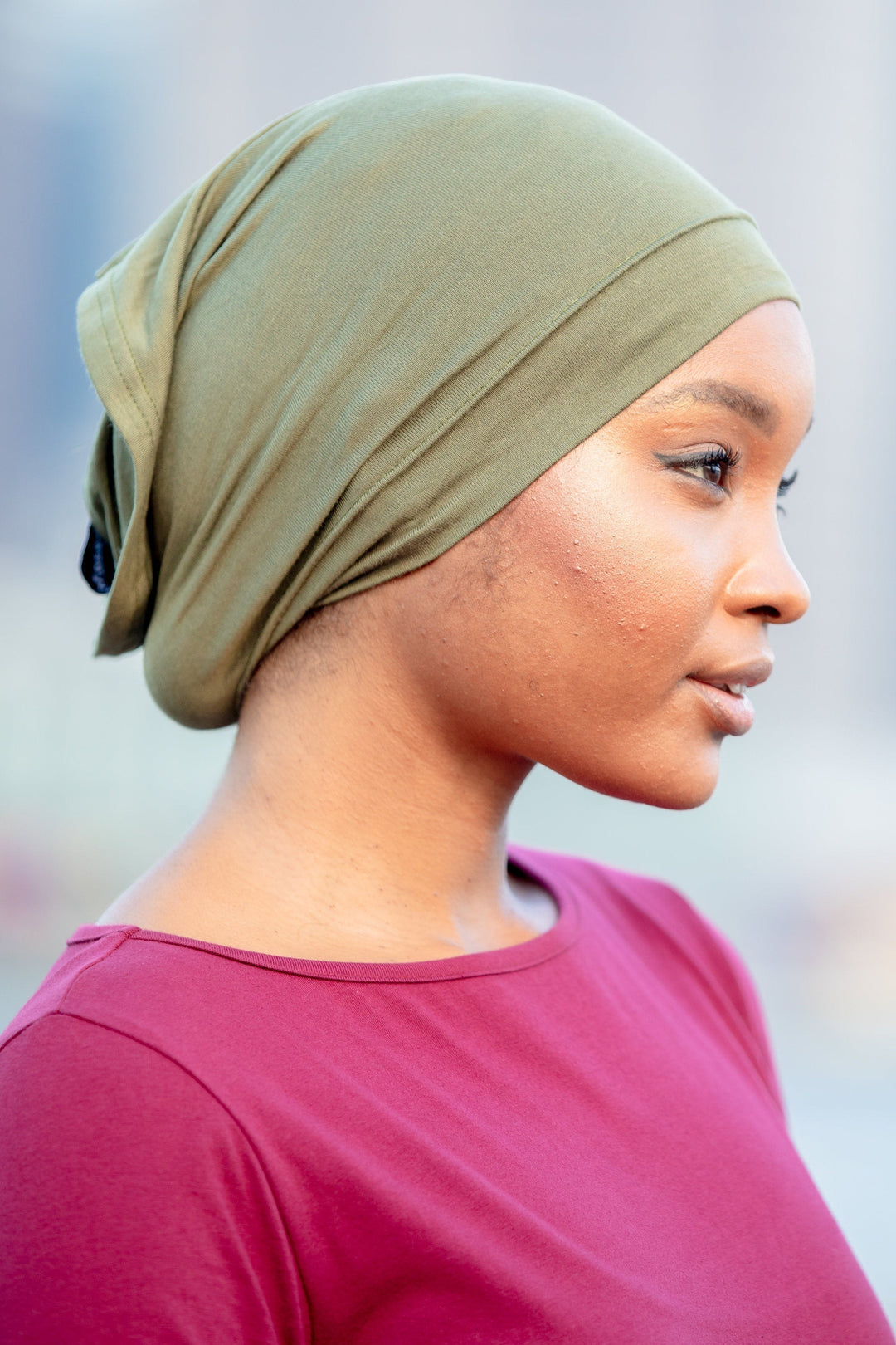 Woman in a green tube hijab underscarf, stylish and versatile accessory