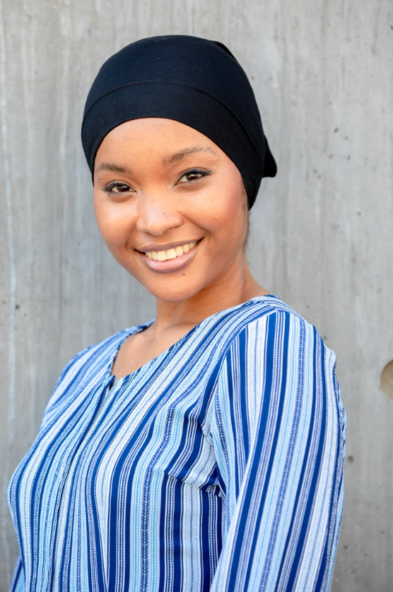 Smiling woman in blue striped shirt wearing a black Tube Hijab UnderScarf