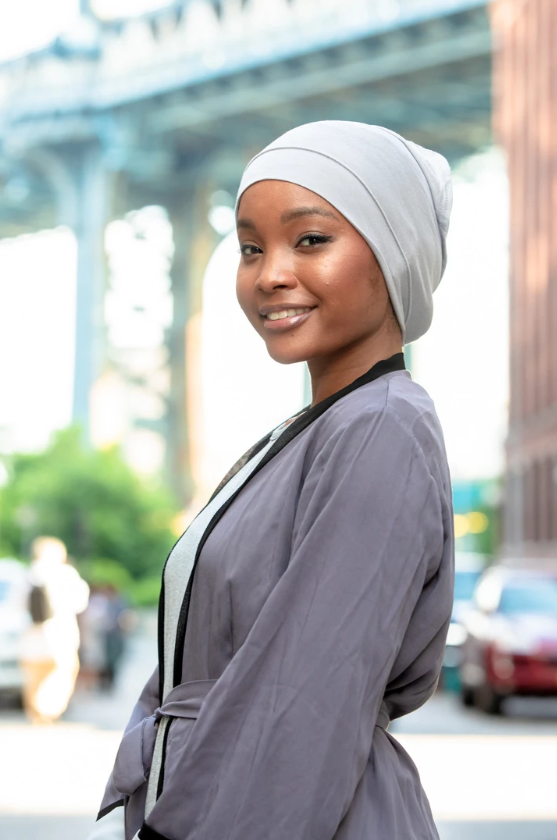 Woman in gray hijab and robe wearing Tube Hijab UnderScarf in various colors