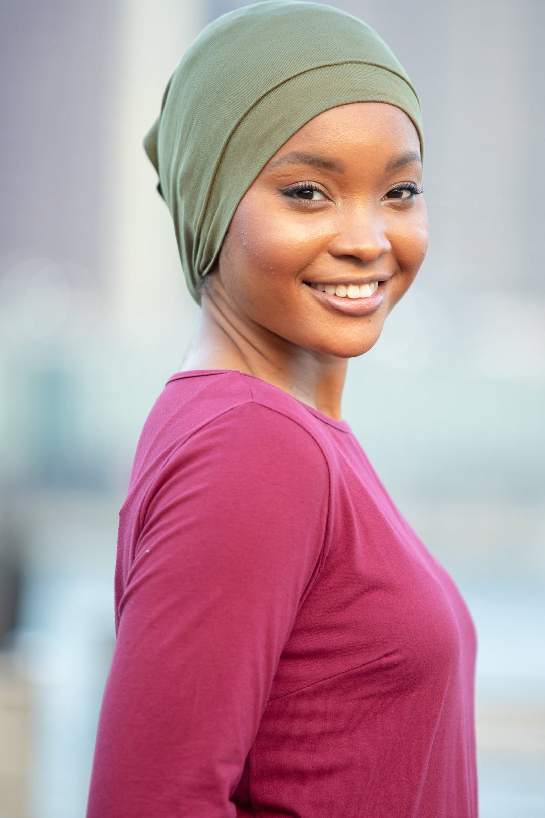 Smiling woman wearing a Tube Hijab Underscarf in stylish long-sleeved shirt