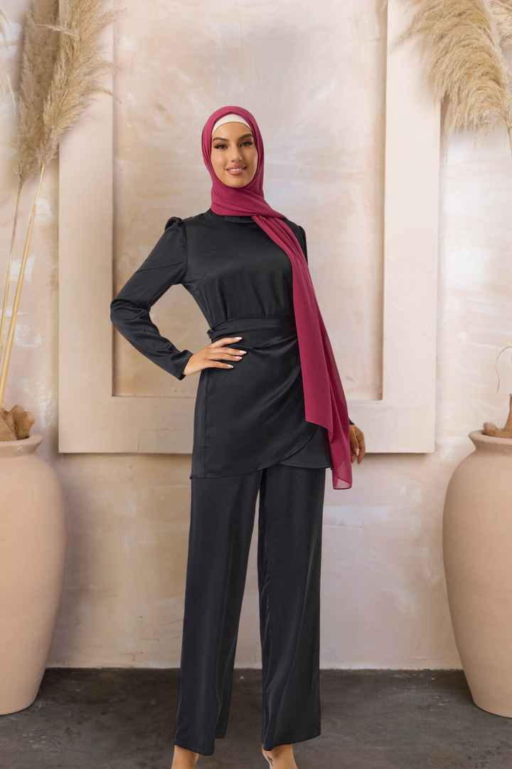 Woman in modest black satin side wrap tunic, pant set and maroon hijab