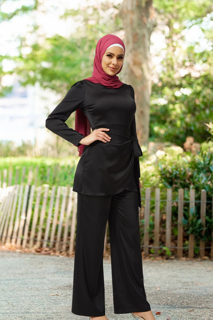 Woman in black satin side wrap tunic and pant set