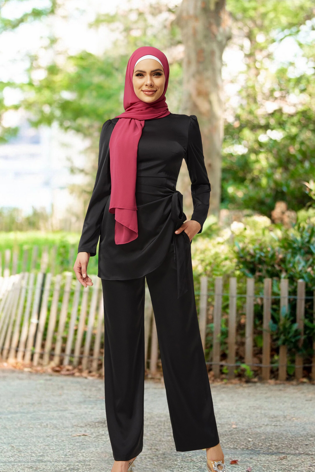Woman in pink hijab wearing black satin side wrap tunic and pant set