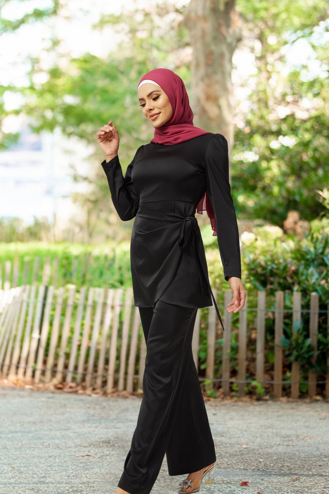 Woman in black satin pantsuit with maroon hijab