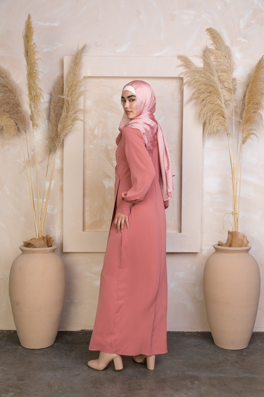 Woman in long pink coral wrap maxi dress and hijab on clearance