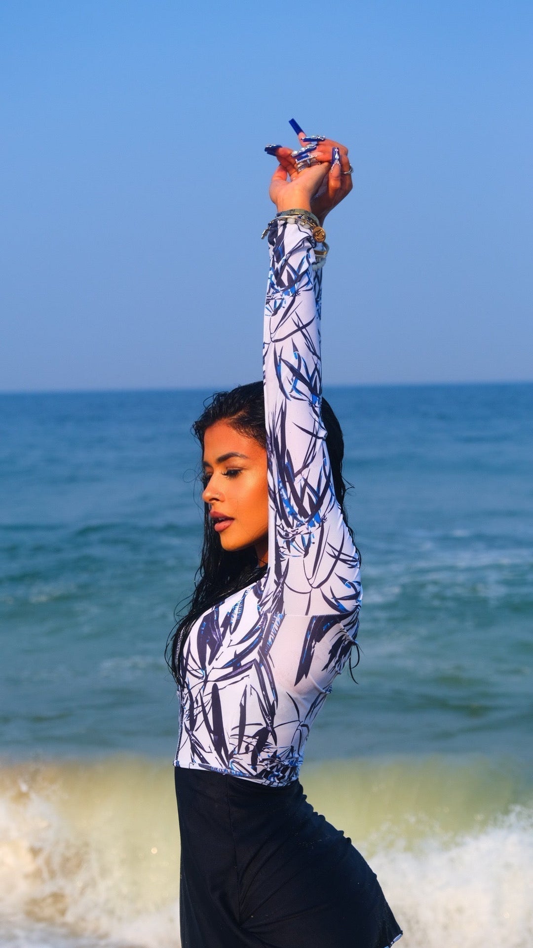 Woman in white and navy floral 3-piece modest swimsuit with patterned rashguard and black skirt