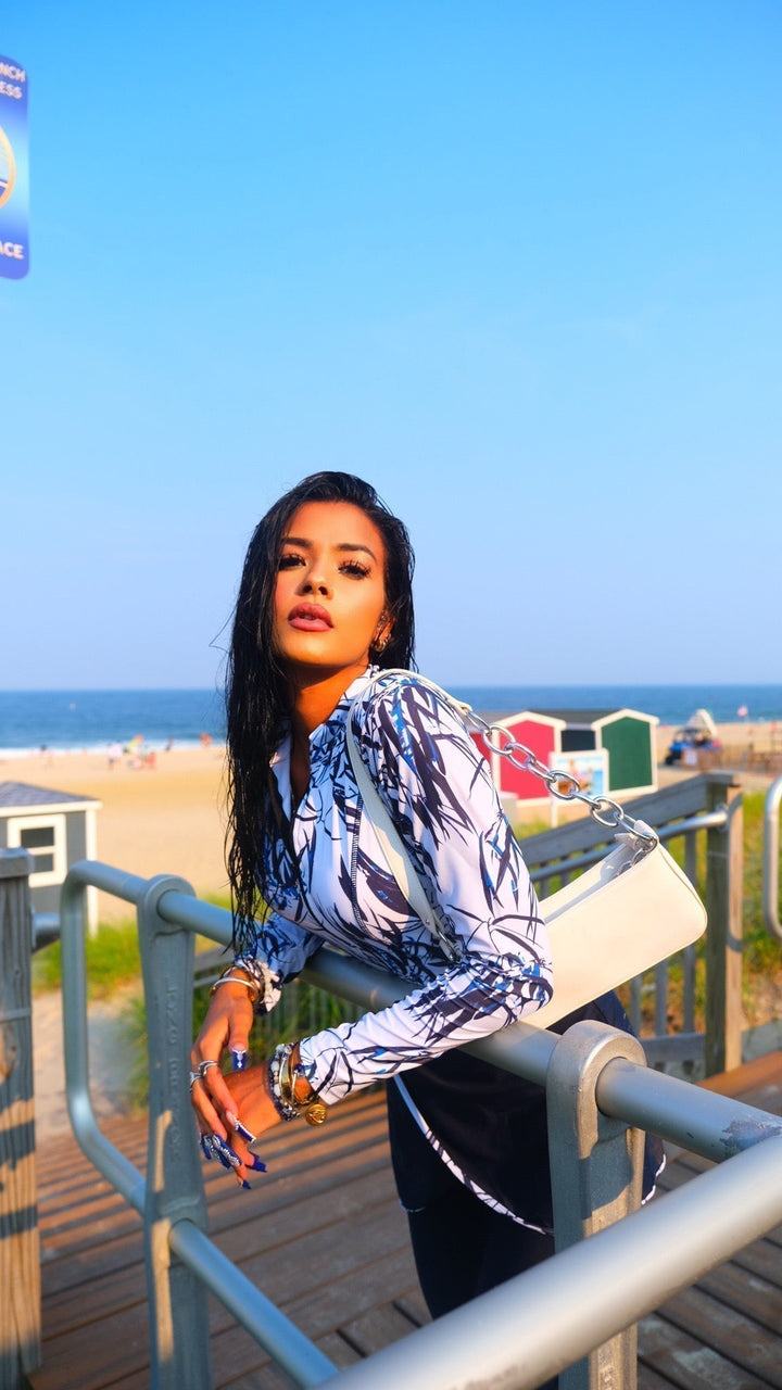 Stylish woman leaning on railing in white and navy floral modest swimsuit