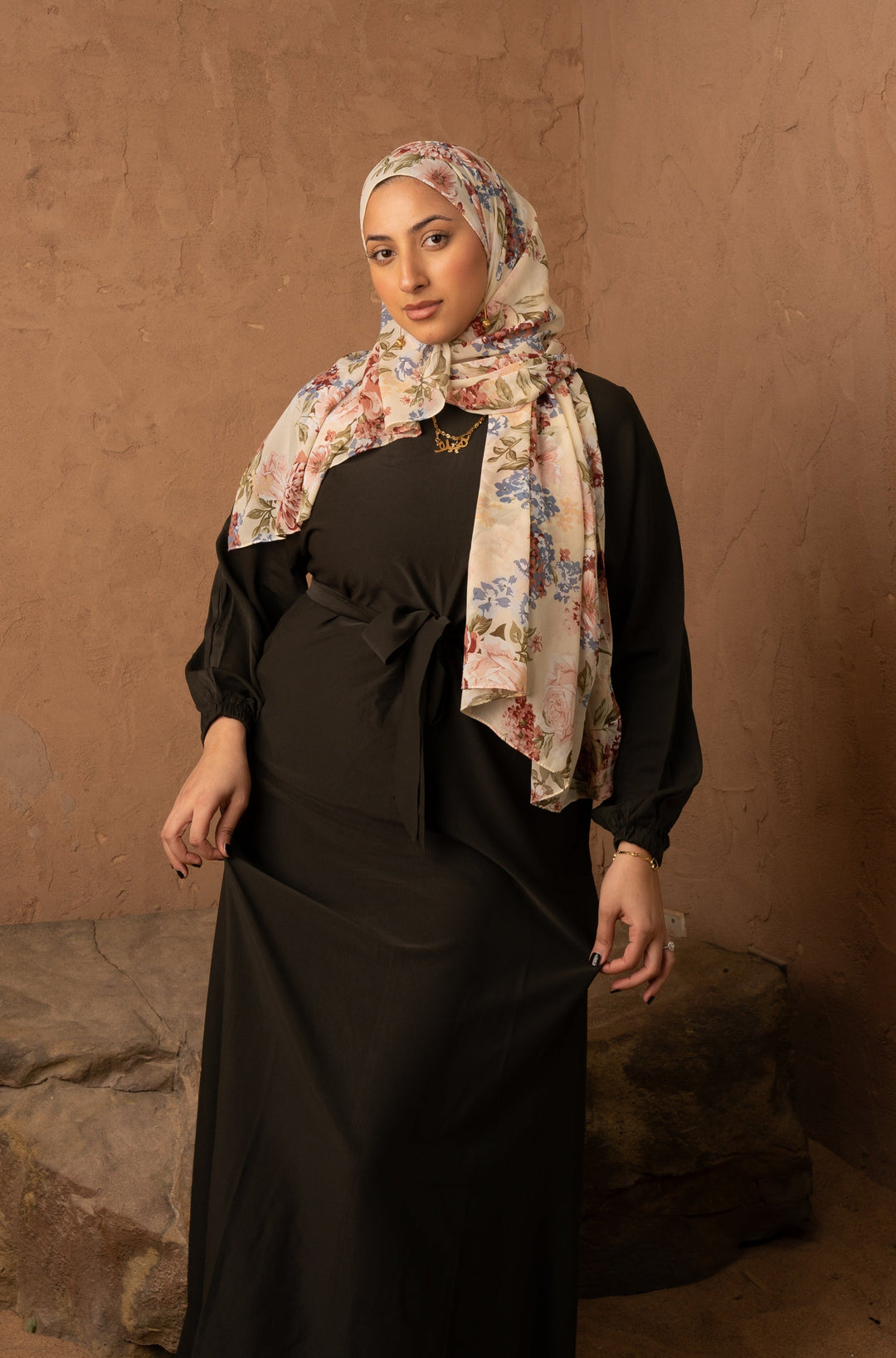 a woman wearing a black dress and a scarf