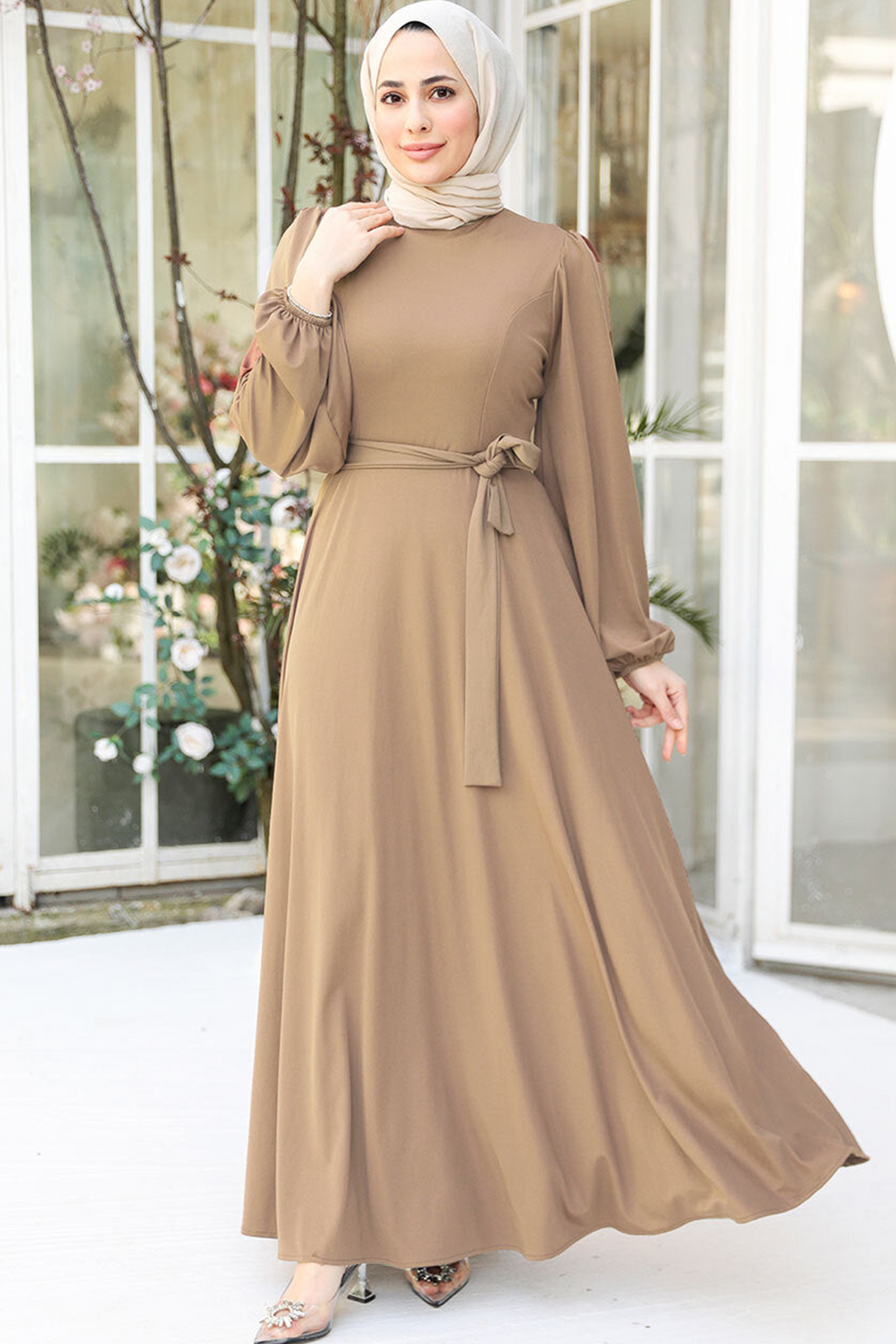 a woman wearing a brown dress with a hijab