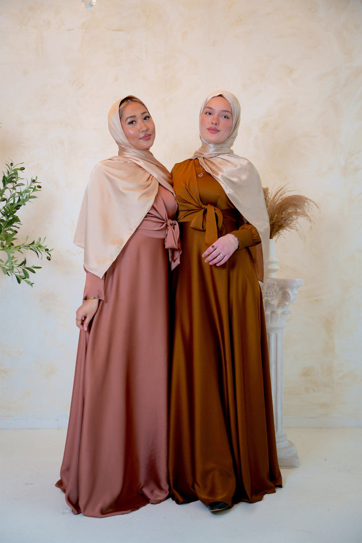 two women standing next to each other in dresses