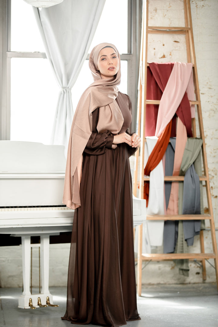 a woman in a hijab standing next to a piano