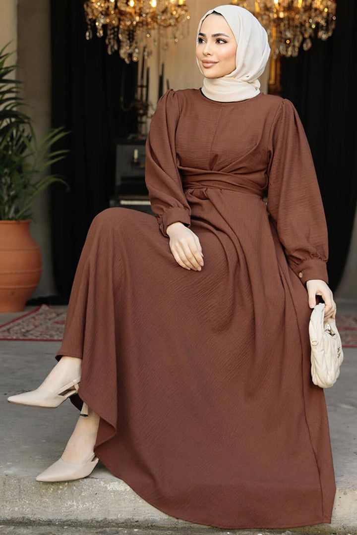 a woman in a brown dress sitting on a step