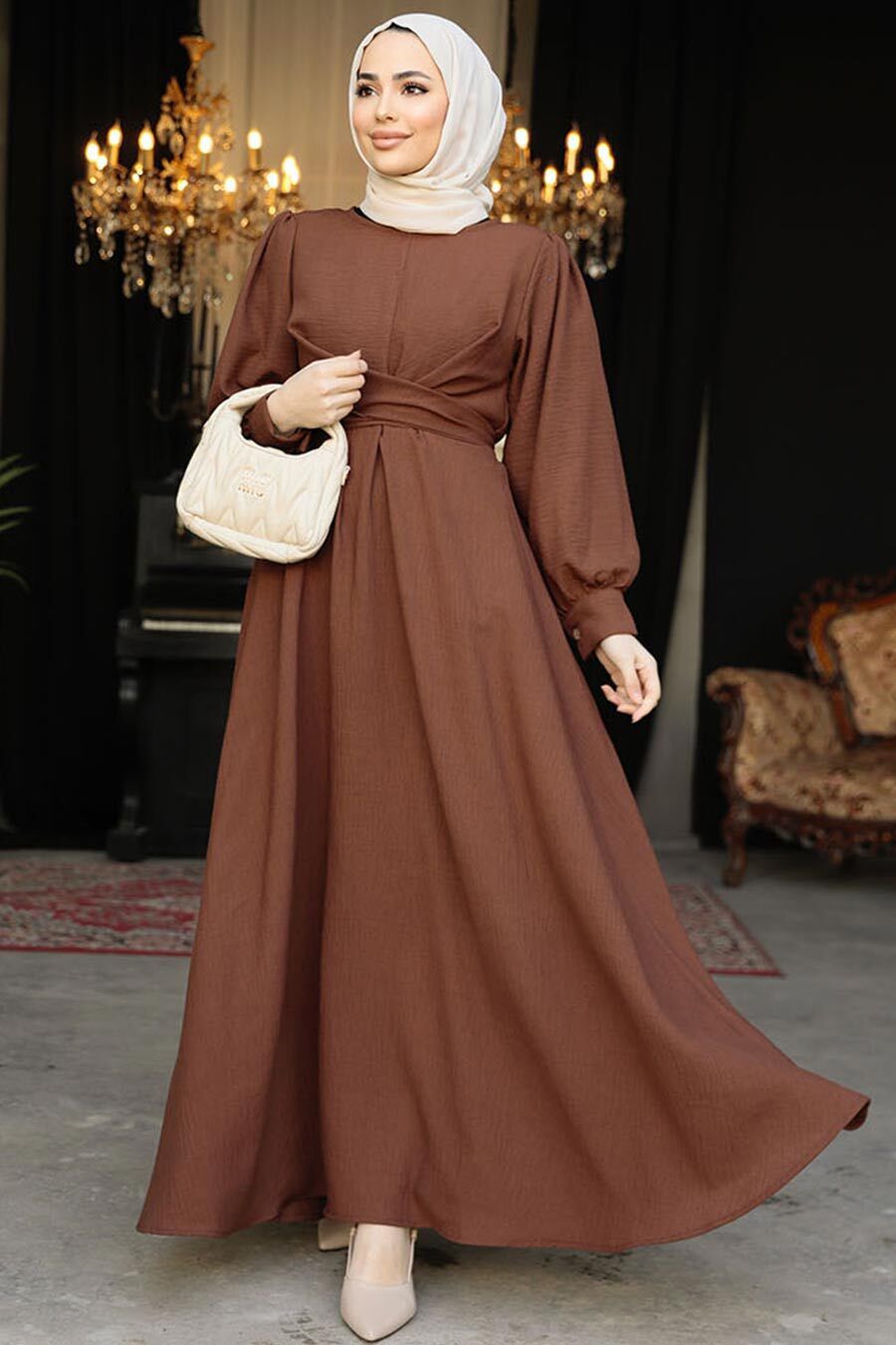 a woman wearing a brown dress and a white purse