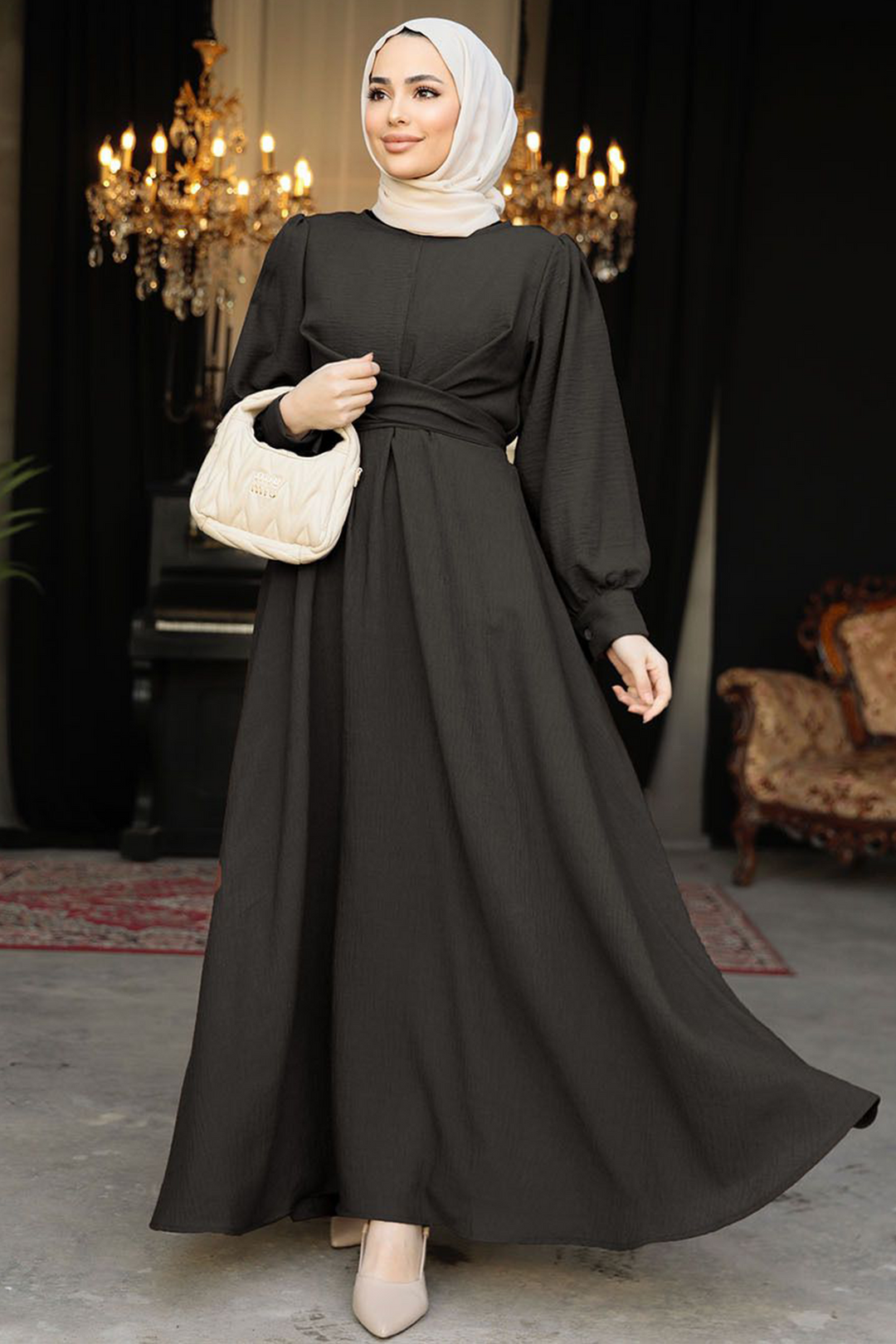 a woman wearing a black dress and a white purse
