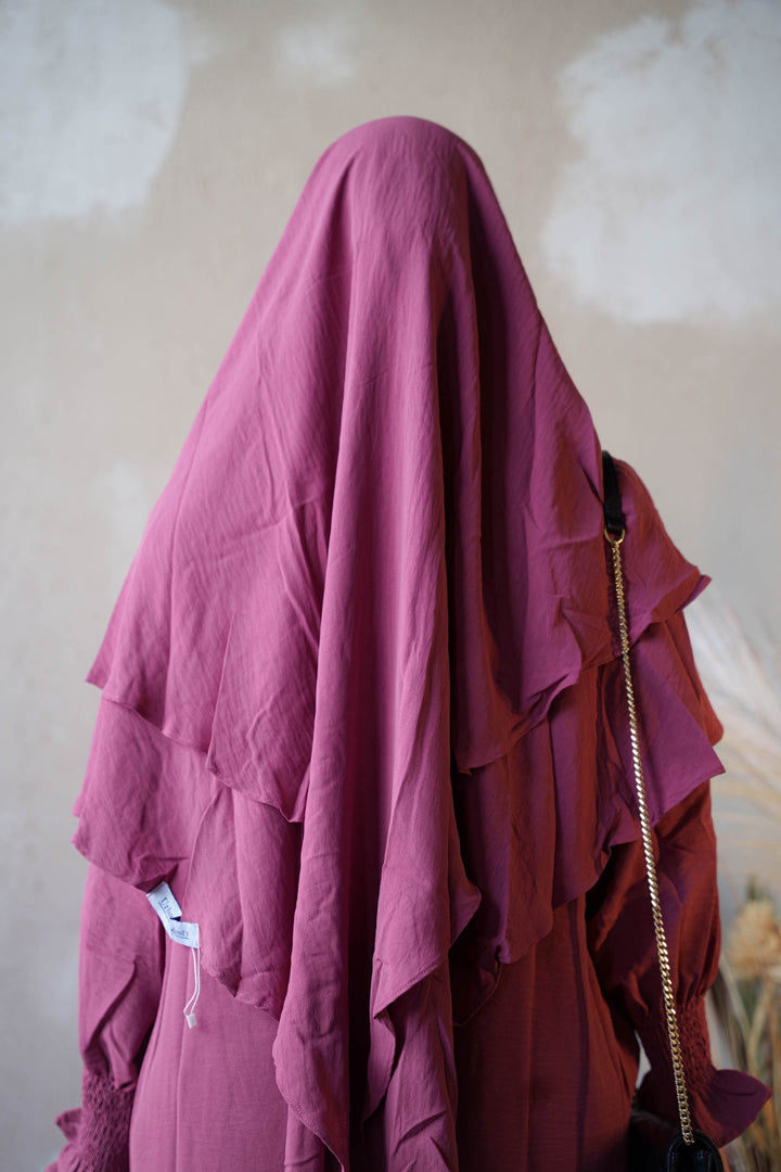 a woman's head covered in a pink cloth