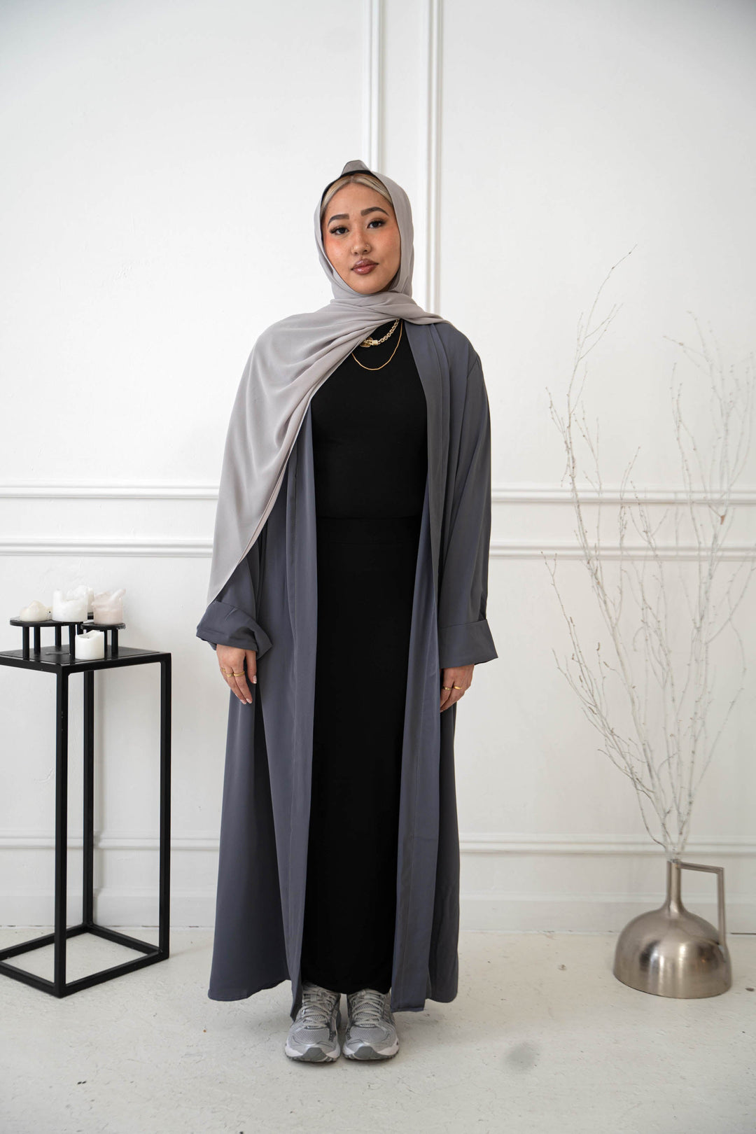 a woman in a black dress and a gray shawl