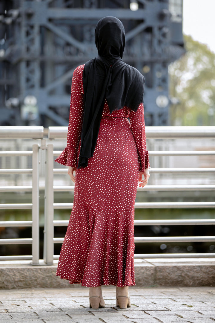 a woman in a red polka dot dress looking at a bridge