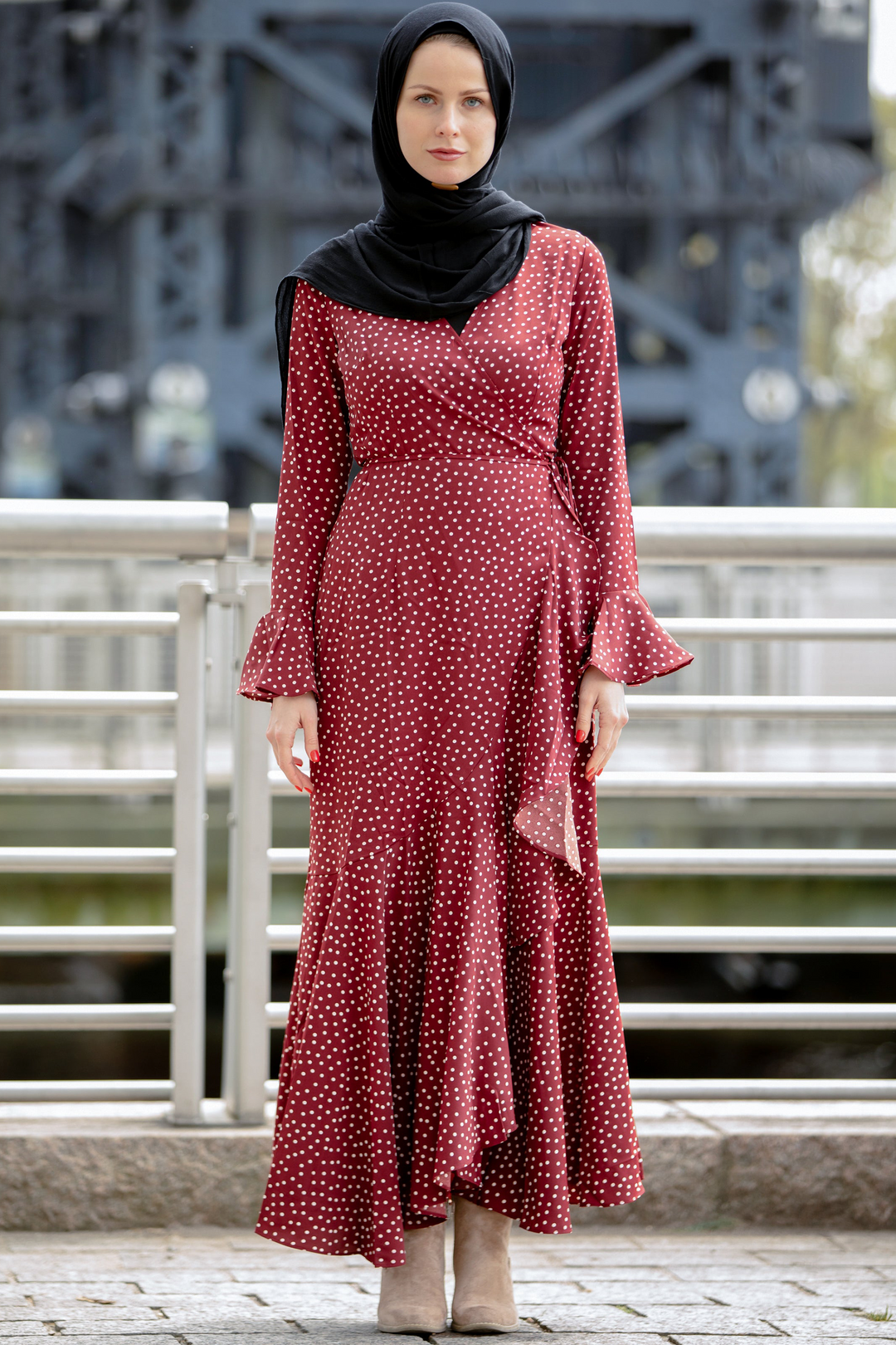 a woman in a red dress standing on a bridge