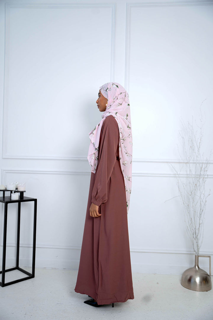 a woman in a hijab standing in front of a wall