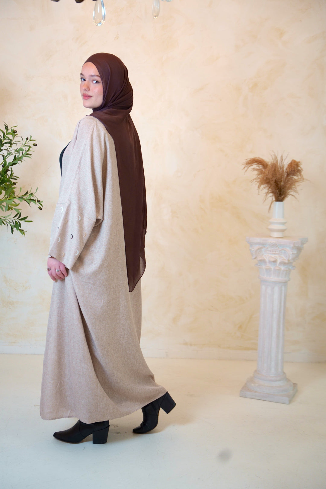 a woman in a hijab is standing in a room