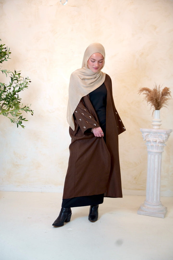 a woman in a brown dress and a brown shawl