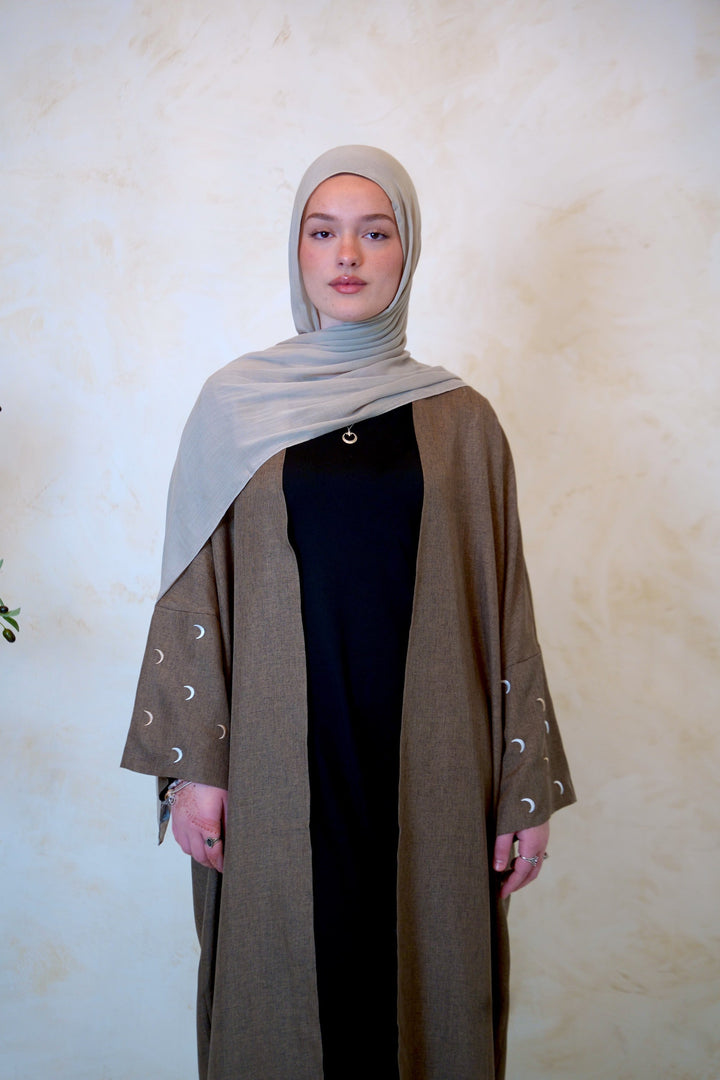 a woman in a black dress and a brown shawl