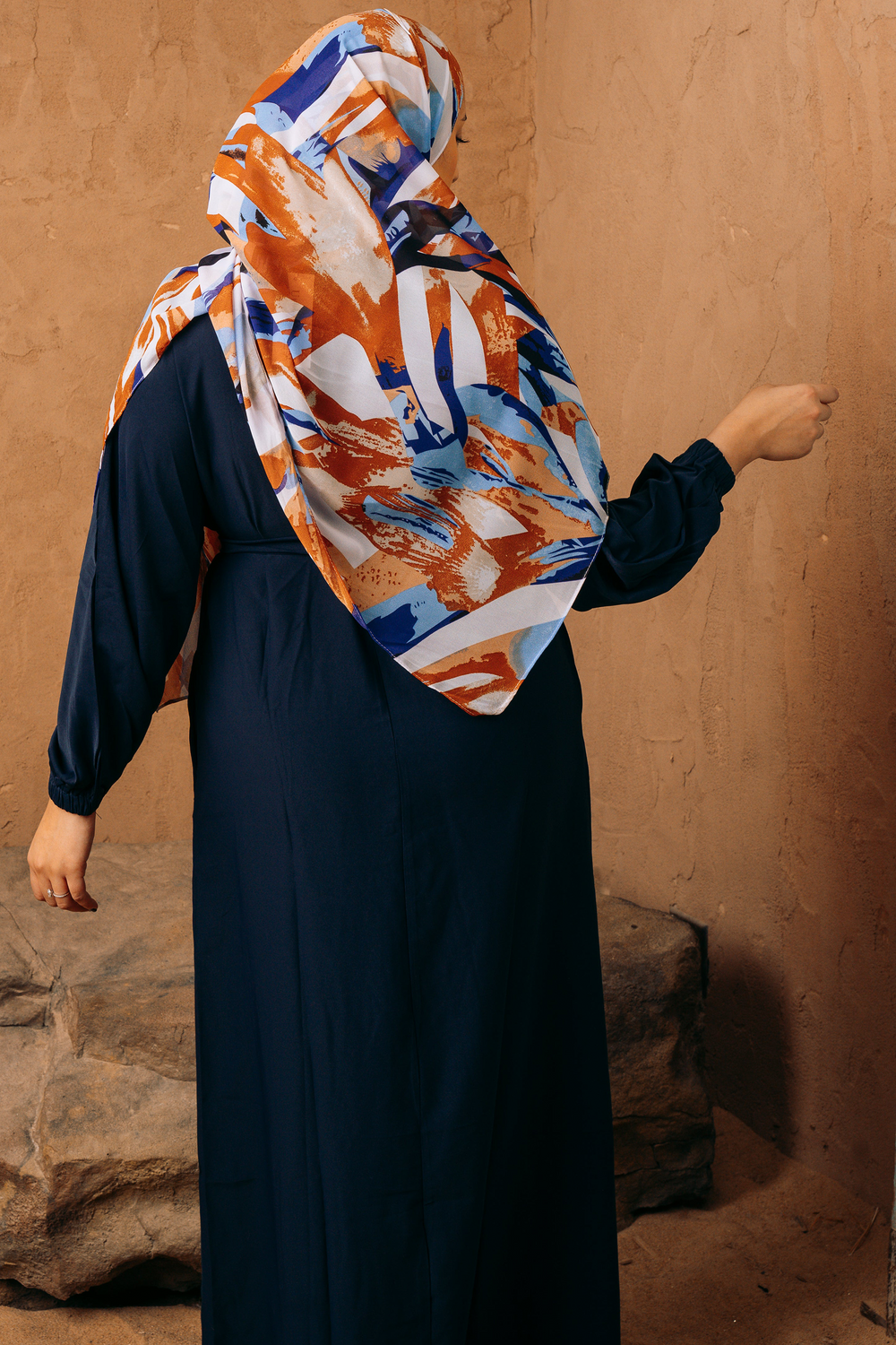 a woman wearing a blue dress and a colorful scarf