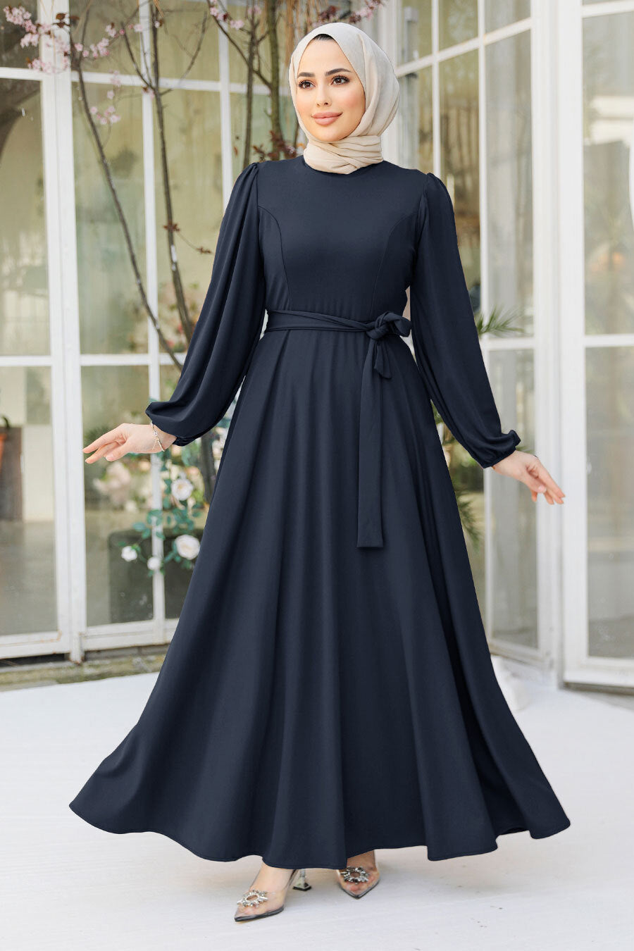 a woman in a black dress with a hijab