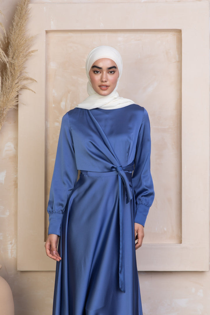 a woman wearing a blue dress with a white head scarf