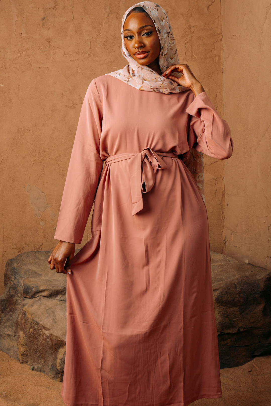 a woman in a pink dress poses for a picture