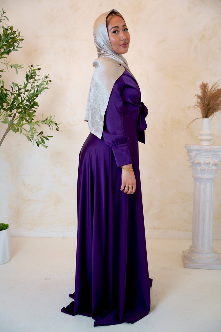 a woman wearing a purple dress and a white shawl