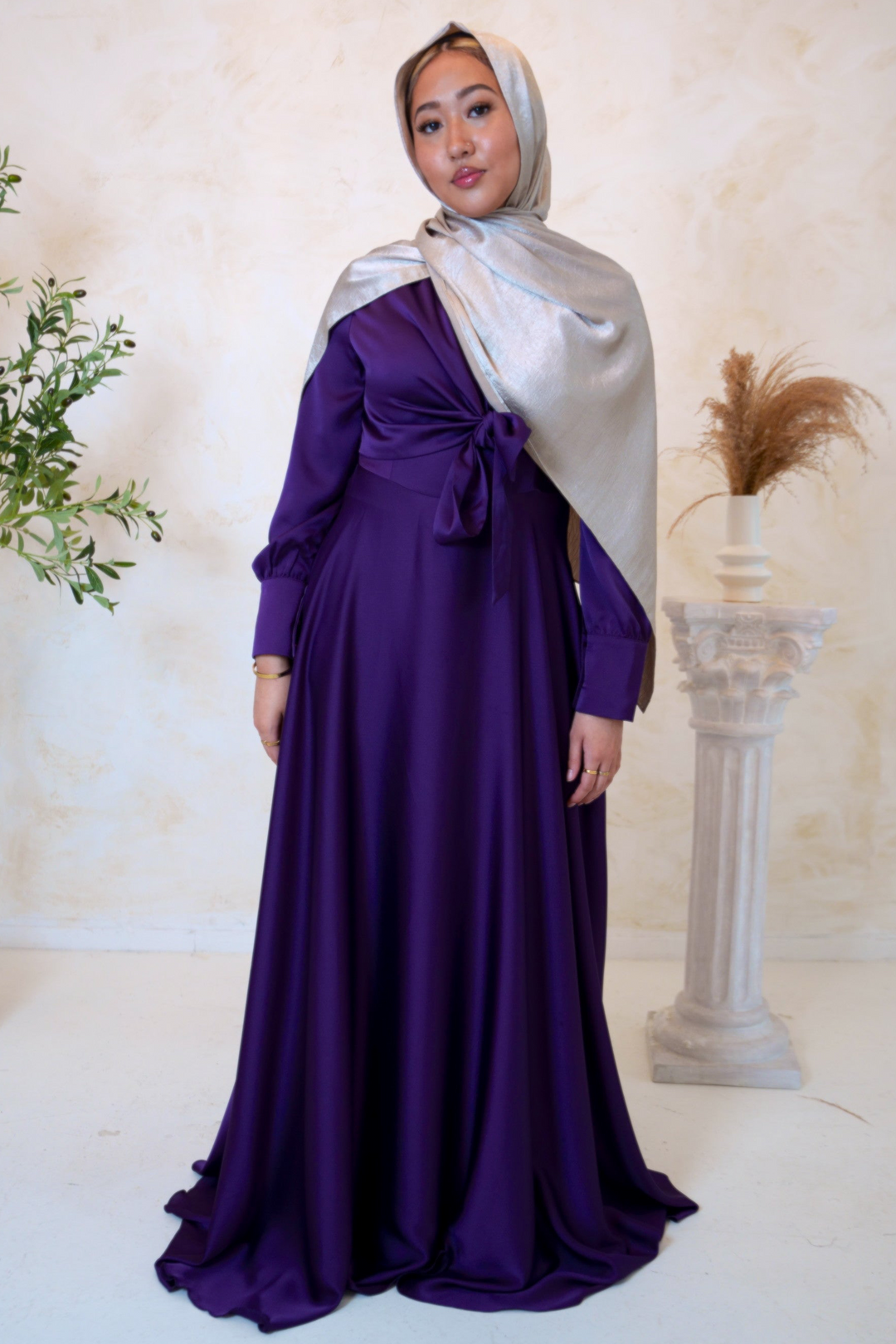 a woman wearing a purple dress and a silver shawl