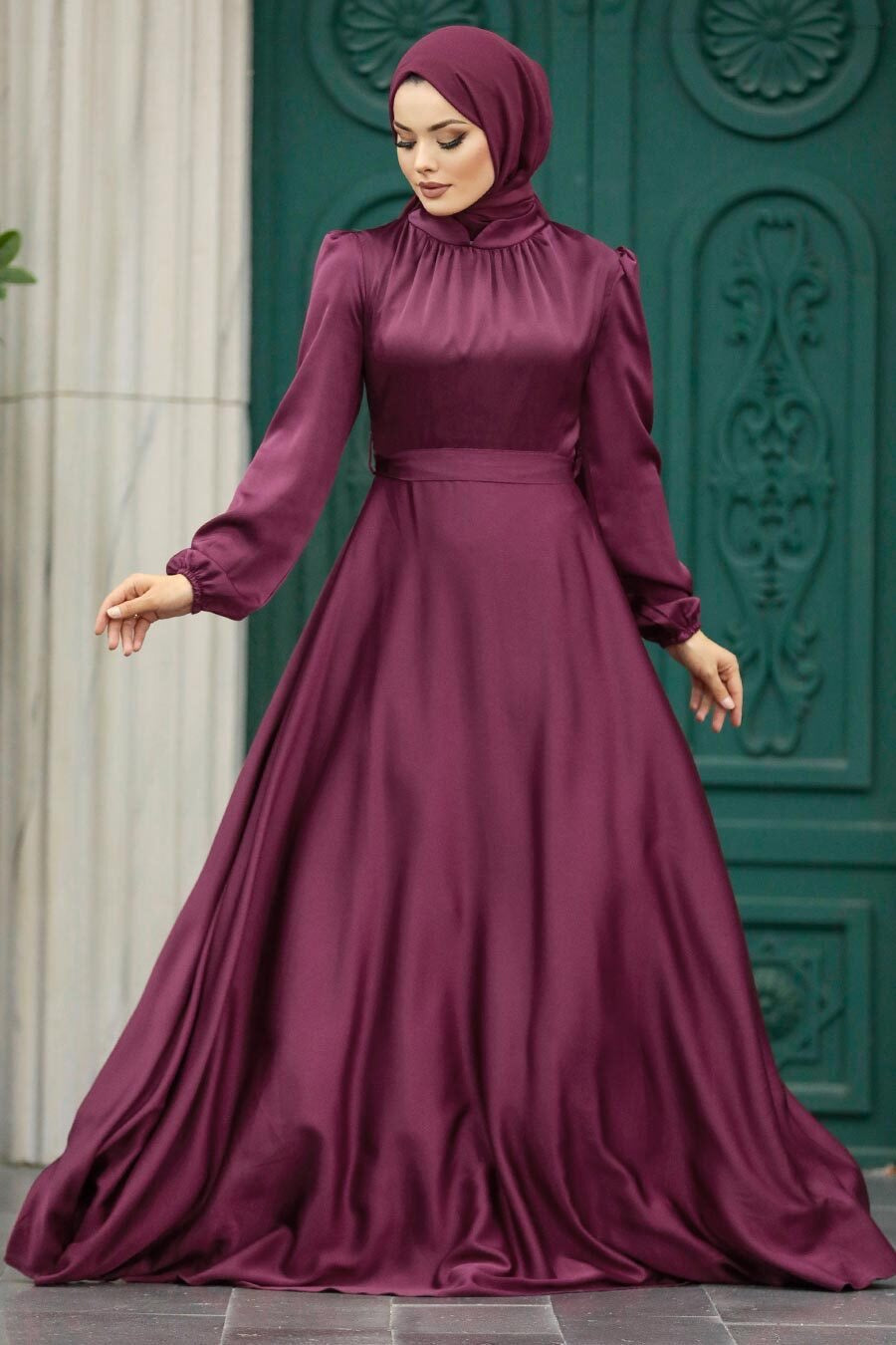 a woman in a long purple dress with a hijab