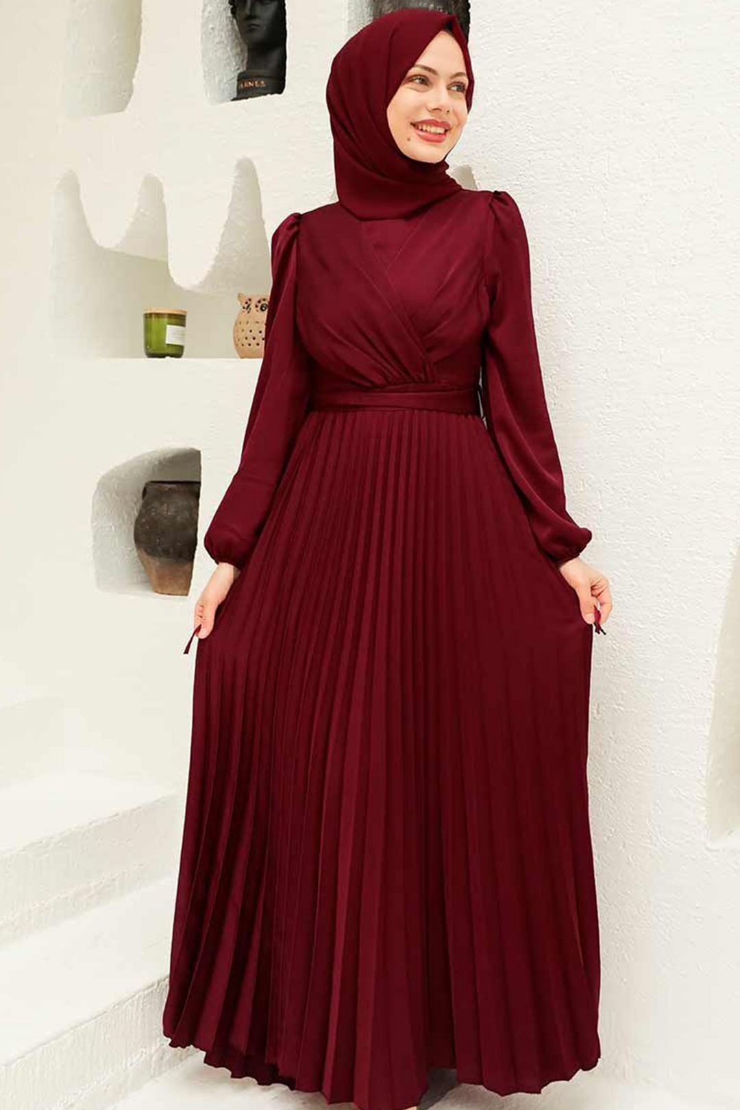 a woman wearing a maroon dress and hijab