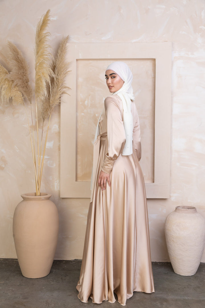 a woman in a hijab standing next to a vase