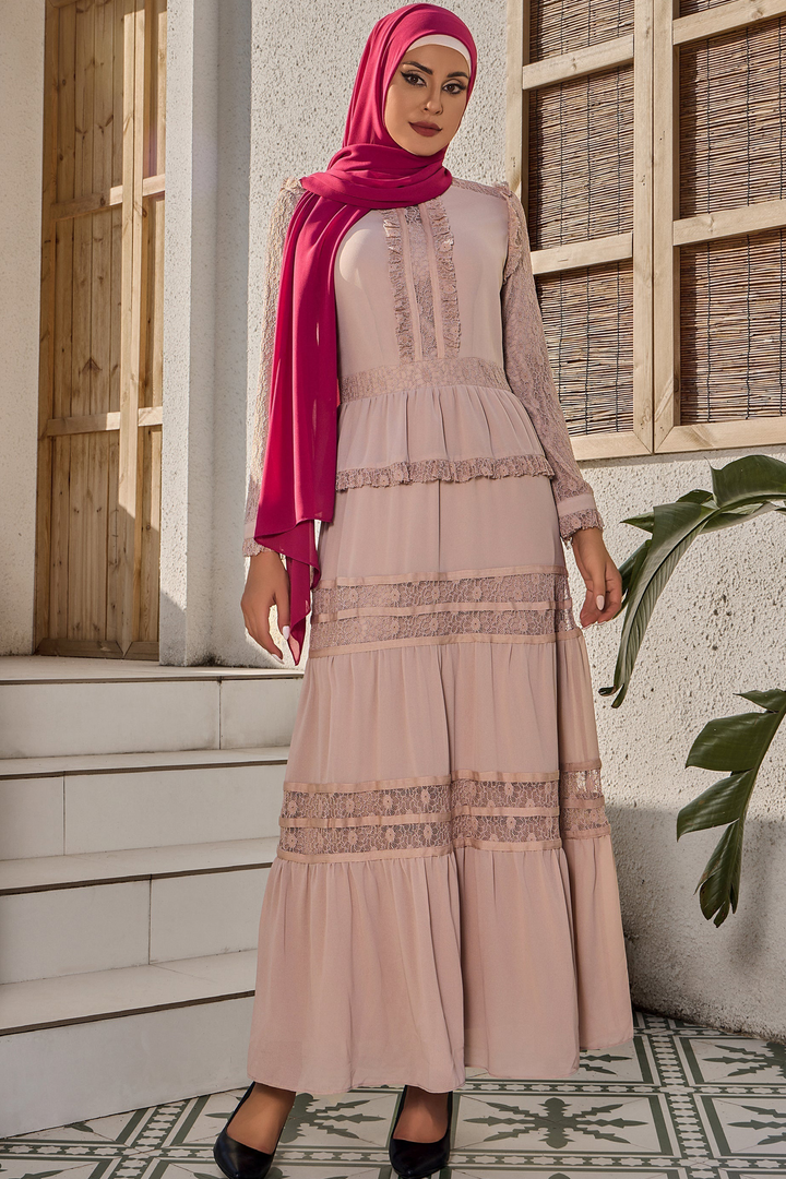 a woman wearing a pink hijab standing in front of a building