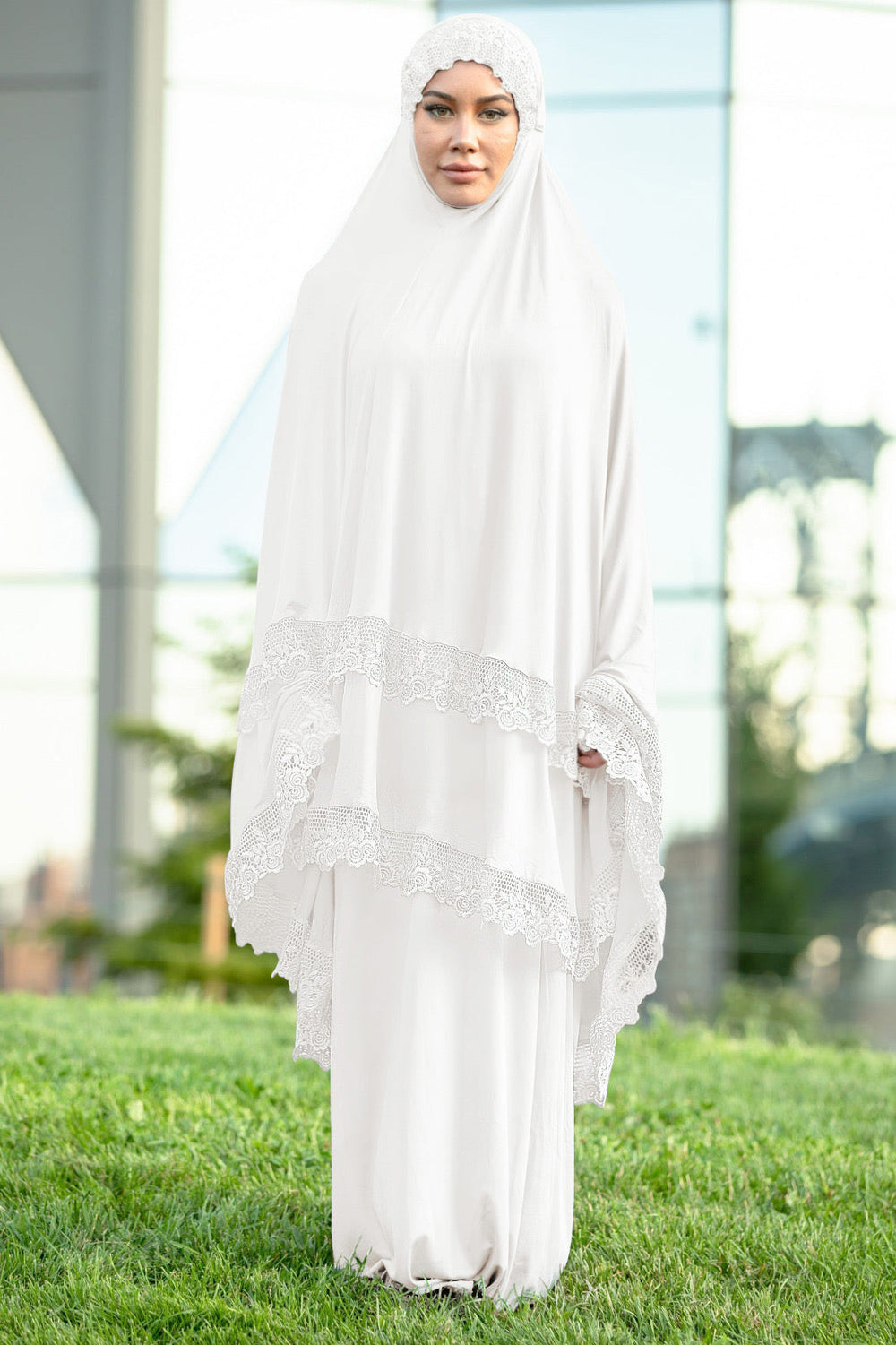 a woman in a white dress standing in the grass