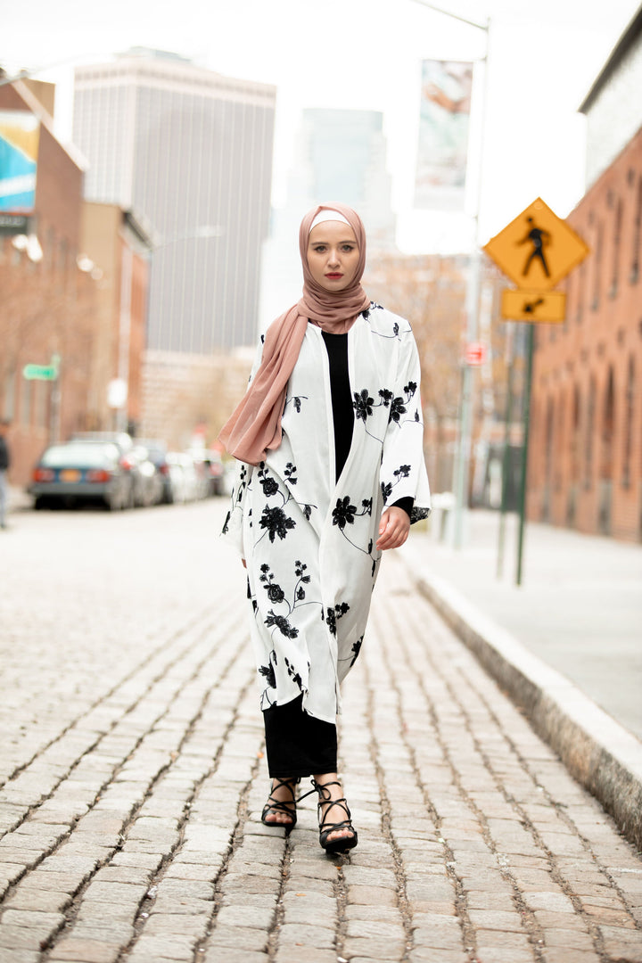 Woman in floral kimono and hijab wearing a black embroidered sheer midi cardigan