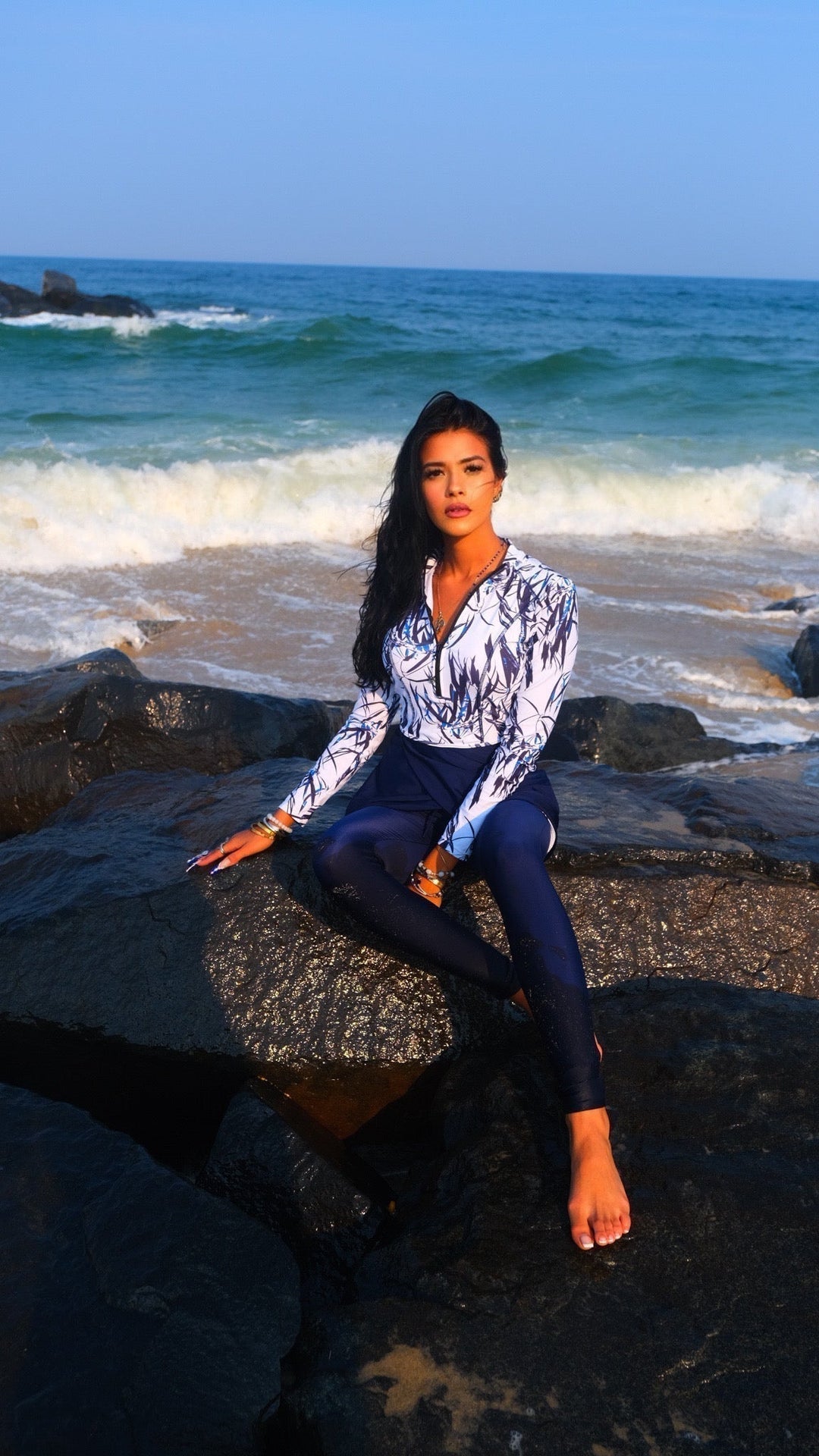 Woman in White and Navy Floral long-sleeved rash guard and leggings for a modest swimsuit