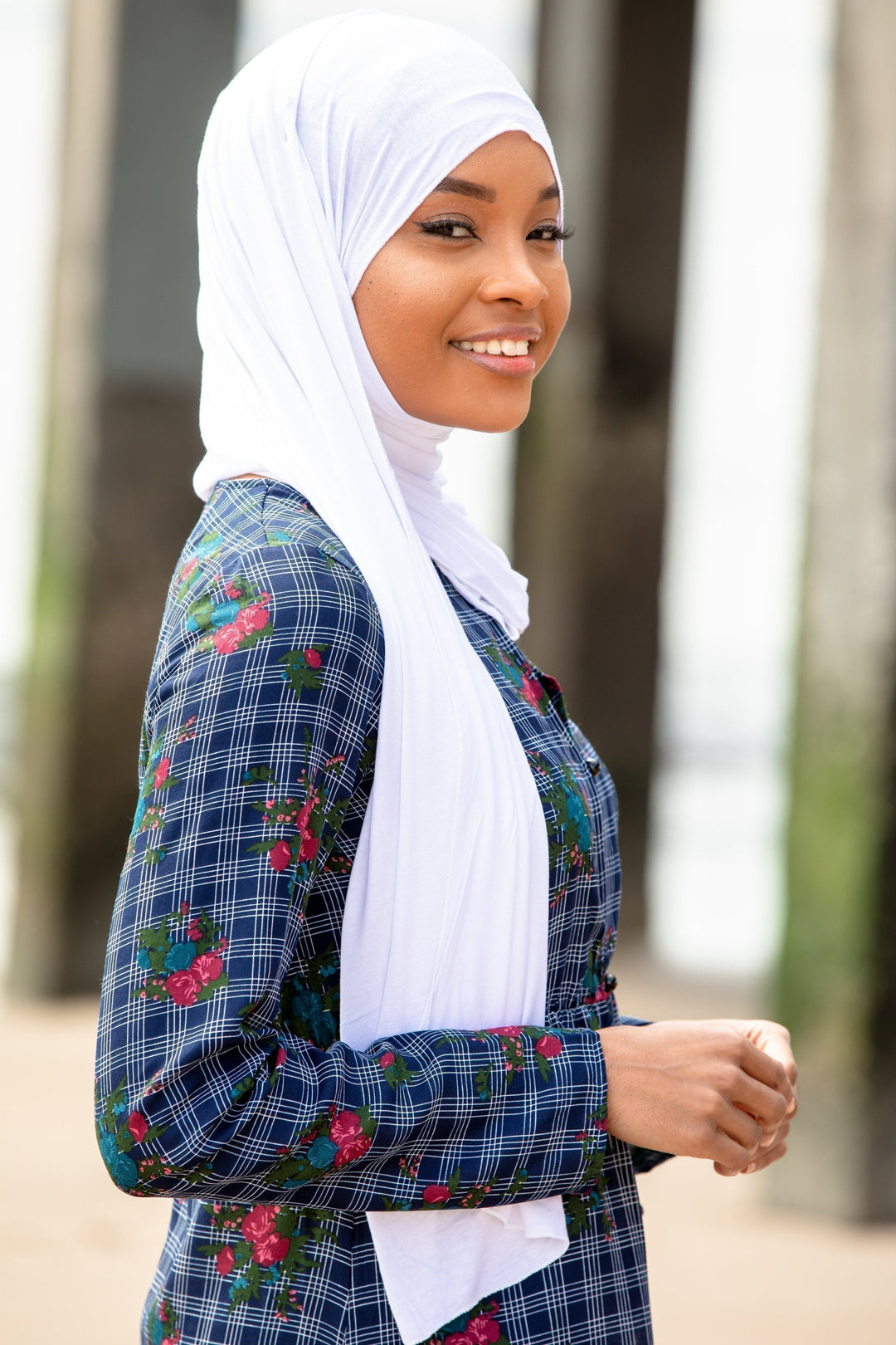 Woman wearing a floral plaid dress with a White Jersey Hijab